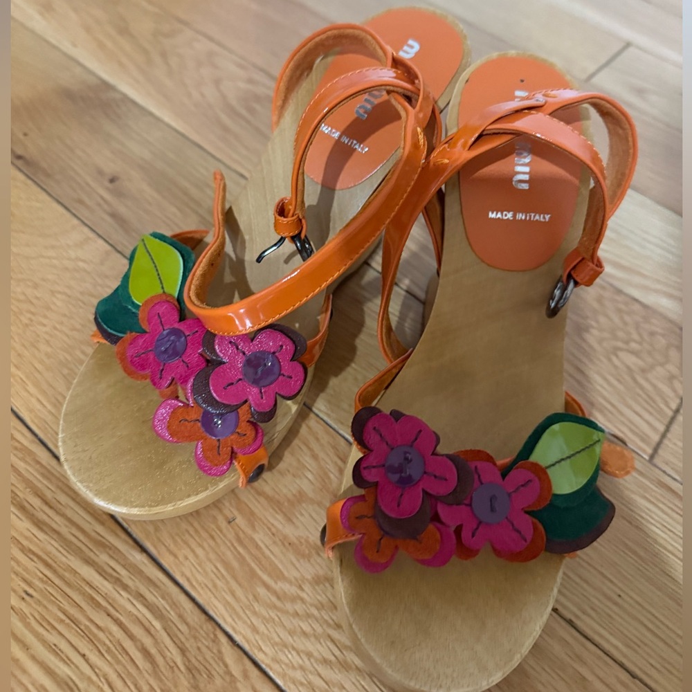Miu Miu wood wedges with flower decal and patent leather ankle strap.